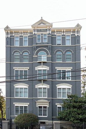 A multi-story building with a dark facade, arched windows, and a sign reading 'ST.PAUL'. - Retro Modern 2 Bdrm 2 Bath Condo (Cincinnati)