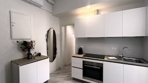 A modern kitchen with white cabinets, a stainless steel sink, and a built-in oven. - DEL RE FLORENCE HOME (Firenze)