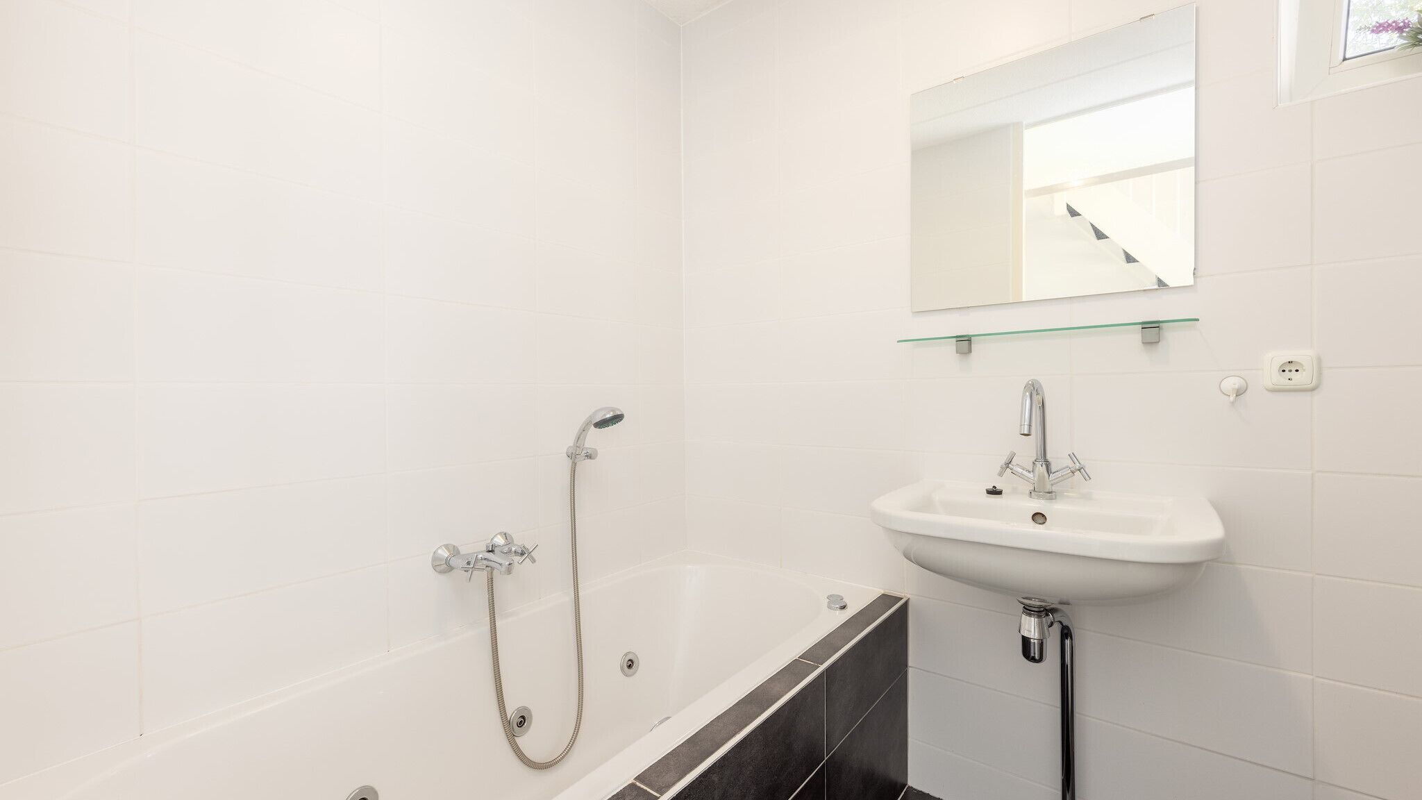 A bathroom with a bathtub, a sink, and a shower.