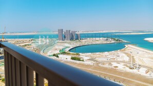 A coastal cityscape with modern high-rise buildings, a marina, and a large body of water. - Bloomfields Premium 1BR Reflection (Abu Dhabi)