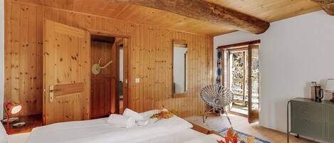 A wooden-paneled room with two beds, a mirror, a fan, and a green cabinet.