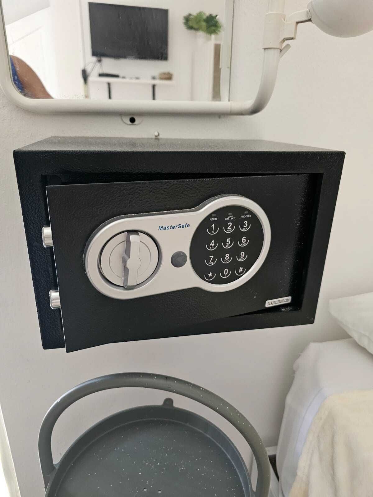 Ein schwarzer MasterSafe-Safes mit Tastatur, an einer weißen Wand befestigt.