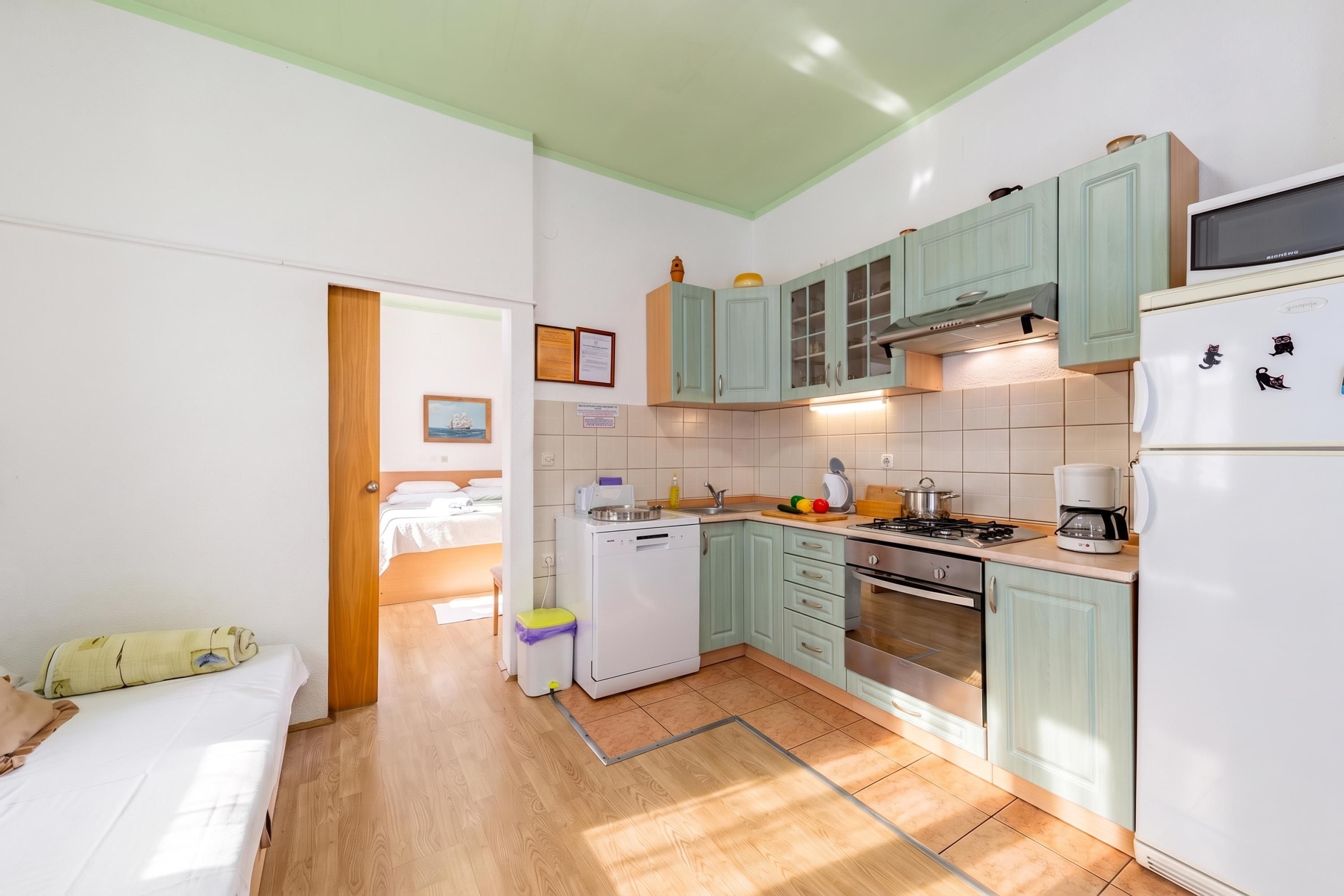 Una cocina compacta con refrigerador, estufa y microondas.