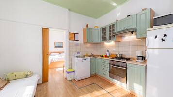 Una cocina compacta con refrigerador, estufa y microondas.