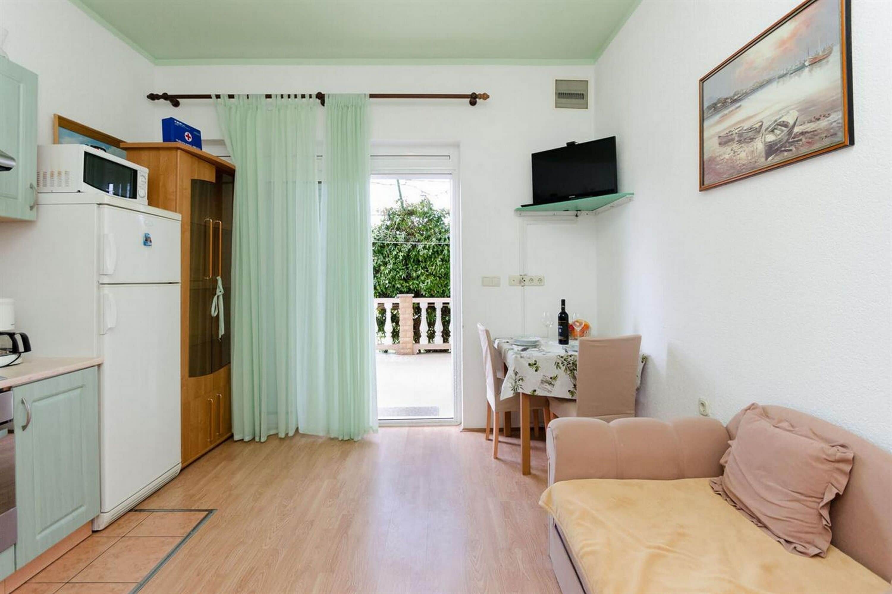 Un espacio habitable compacto con kitchenette, comedor y sofá.