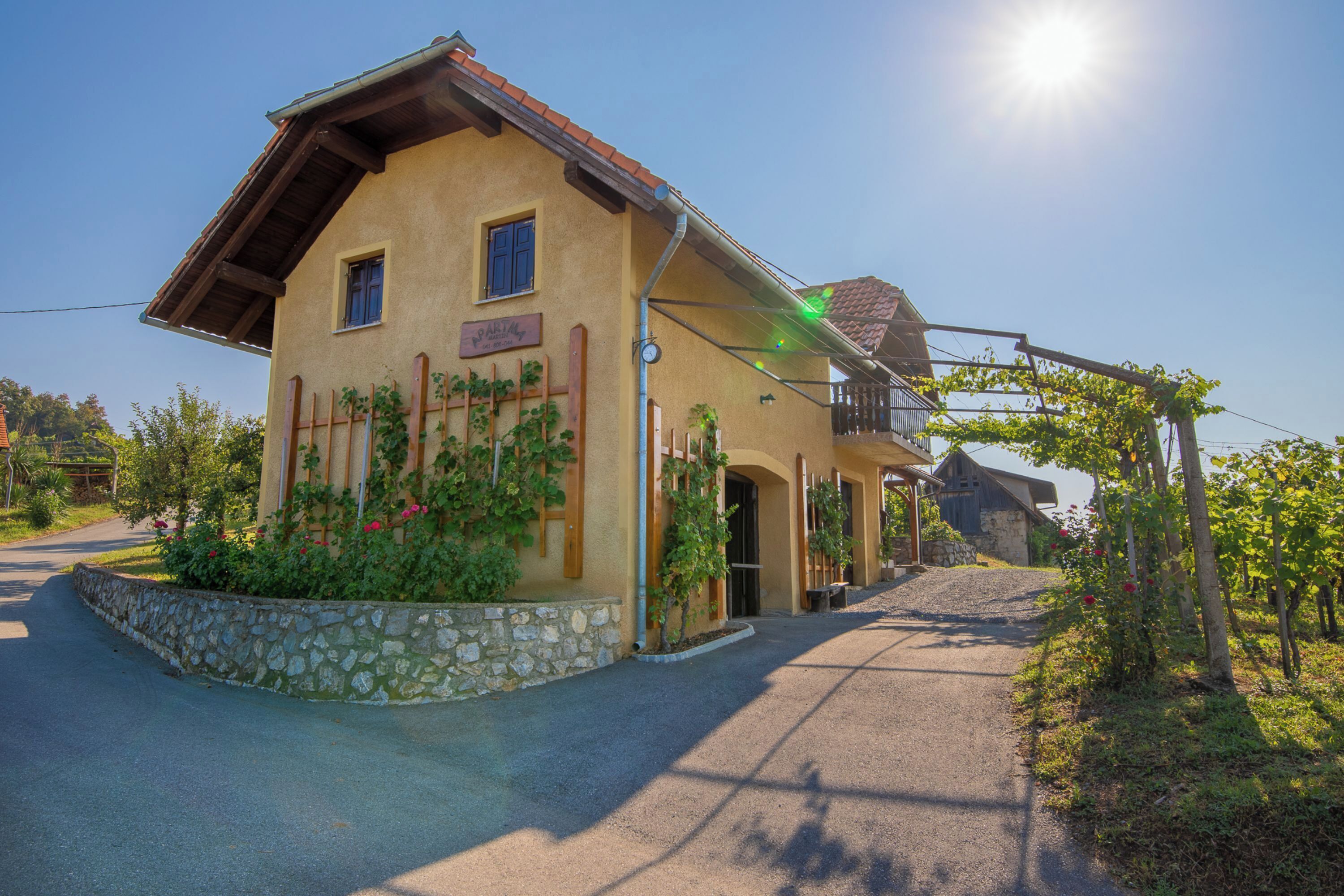 Un bâtiment à deux étages, doté de fondations en pierre, d’un balcon et d’une enseigne indiquant « Hôtel ».