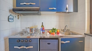 Une cuisine moderne avec des meubles bleus, une cuisinière à gaz et un évier.