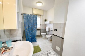 A bathroom with a bathtub, toilet, and shower area. - La Pietra sul Mare Apartment With Terrace (Pietra Ligure)