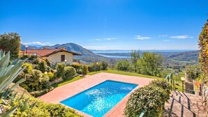 A pool with a mountain view, surrounded by greenery and a house. - Lakeview Bliss / Pool & Fenced Garden (Villanuova sul Clisi)