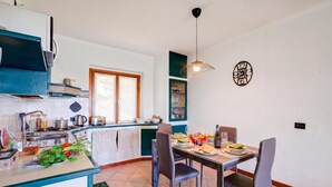 A modern kitchen with a dining area, featuring a central island, a window, and a hanging light fixture. - Lakeview Bliss / Pool & Fenced Garden (Villanuova sul Clisi)
