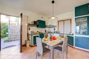 A compact kitchen with a dining area, a microwave, and a sink. - Lakeview Bliss / Pool & Fenced Garden (Villanuova sul Clisi)