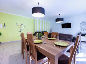 A dining area with a wooden table, chairs, and hanging pendant lights.