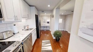 A modern kitchen with white cabinets, a stainless steel toaster, and a dishwasher.
