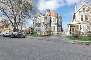 A Victorian-style house with a prominent turret, large windows, and a well-maintained lawn.