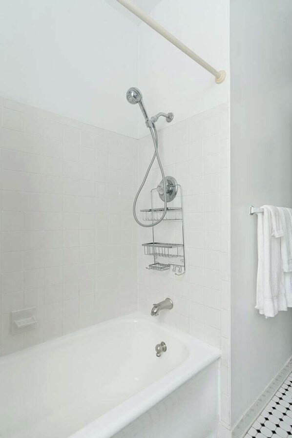 Un baño con bañera, ducha y perchero.