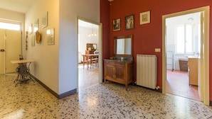 A hallway with a speckled floor, a wooden cabinet with a mirror, and a dining area in the background. - Countryside House Near To Pratomagno (Terranuova Bracciolini)