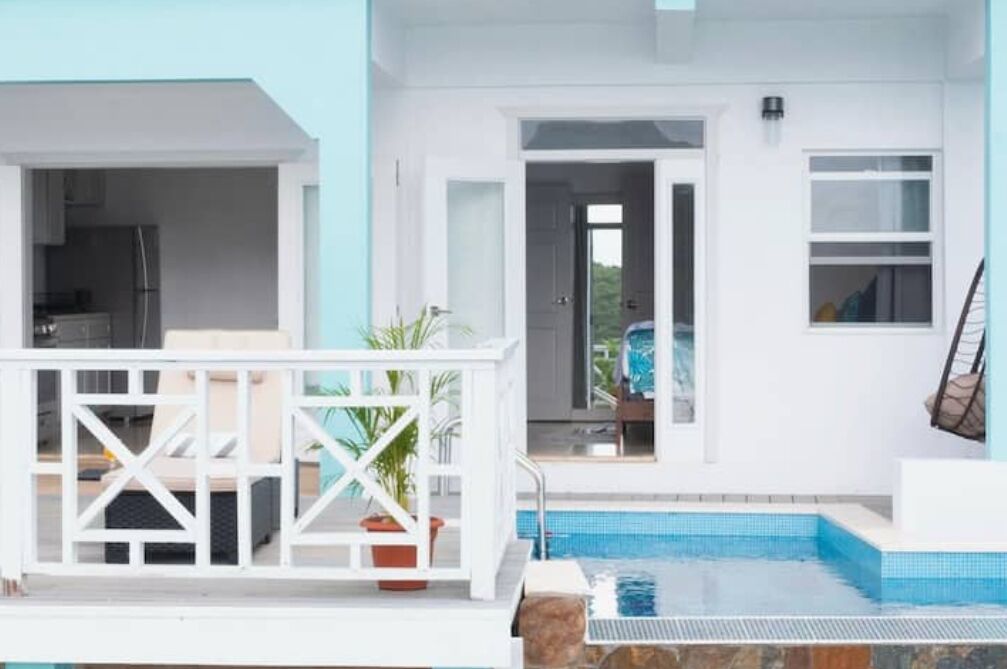 Um edifício moderno com piscina, área externa coberta e cozinha visível.