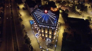 Un edificio de varios pisos con una cúpula central característica y una serie de balcones.