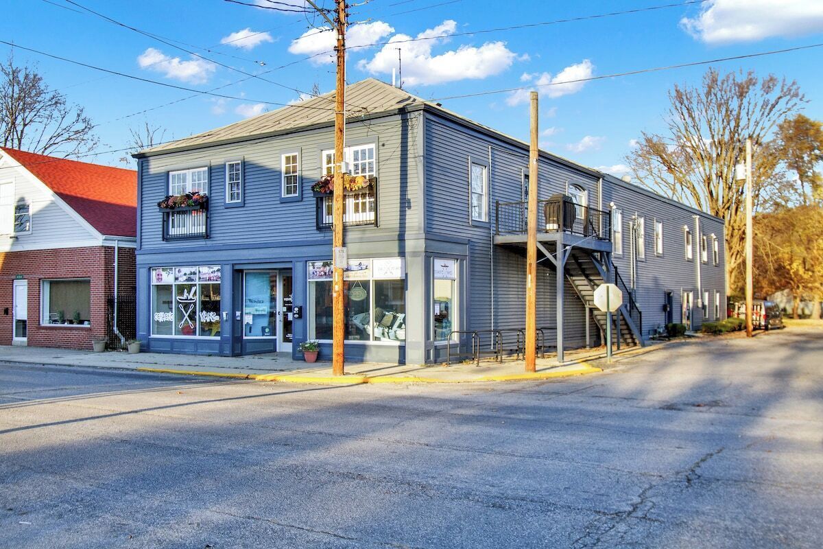 A two-story building with a storefront on the ground floor and a staircase leading to an upper level.