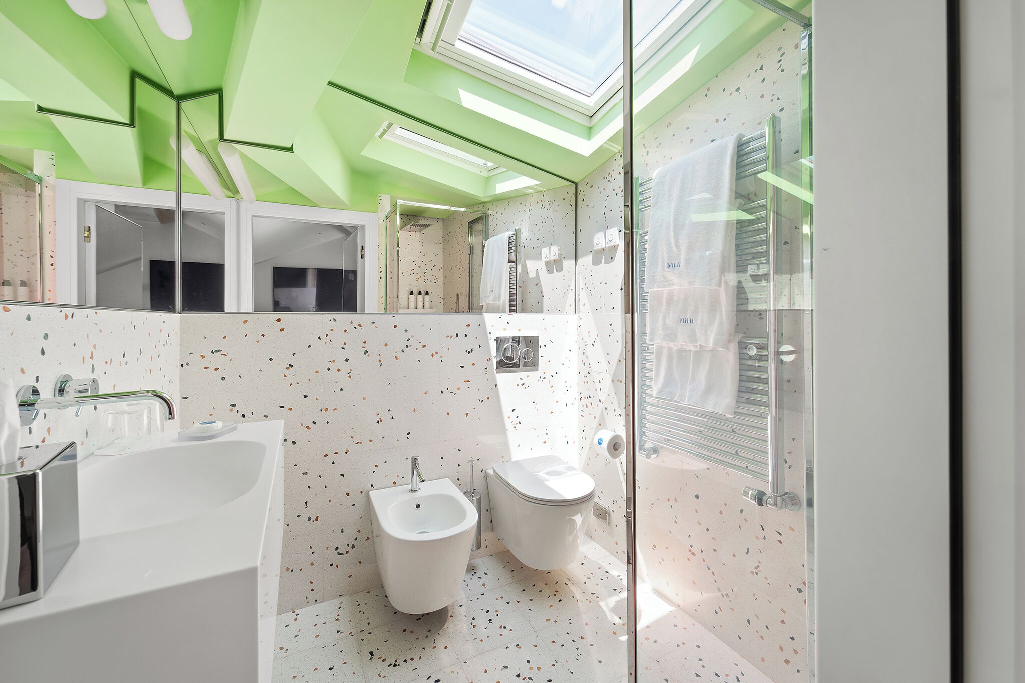A modern bathroom with a bidet, toilet, and bathtub.