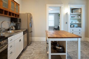 A modern kitchen with a wooden table, stainless steel appliances, and a built-in oven.