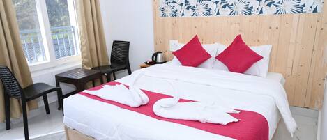 Una camera d'albergo con un letto, una testiera in legno, una scrivania, una sedia e una finestra con tende.