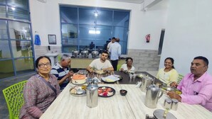 Un grupo de personas comiendo en una mesa con diferentes platos y cubiertos.