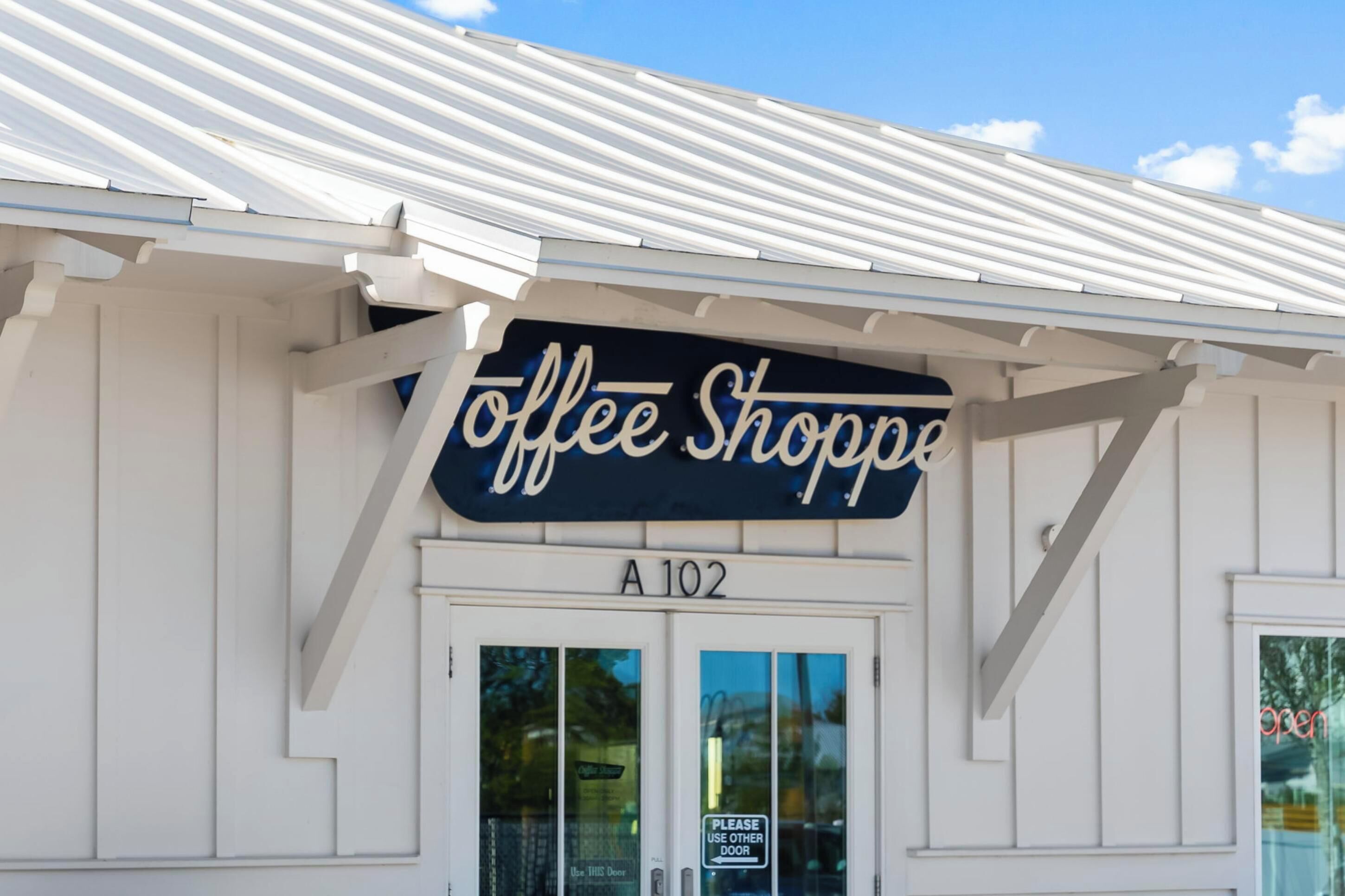 Un edificio con un letrero que dice "Coffee Shoppe" y una puerta con la etiqueta "A 102".