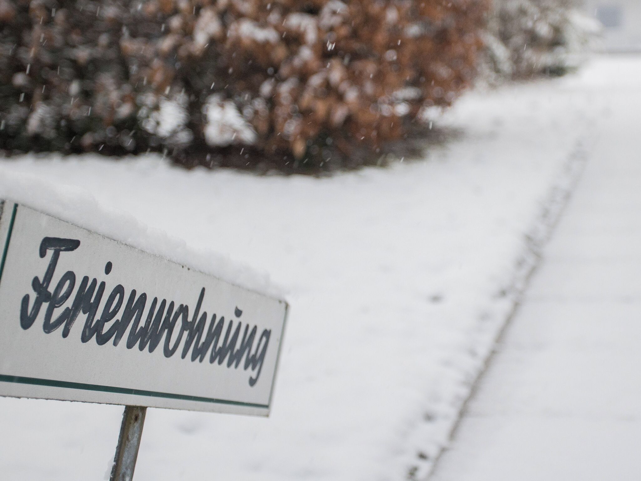 A sign with the text "Feriendorf" in a snowy landscape.