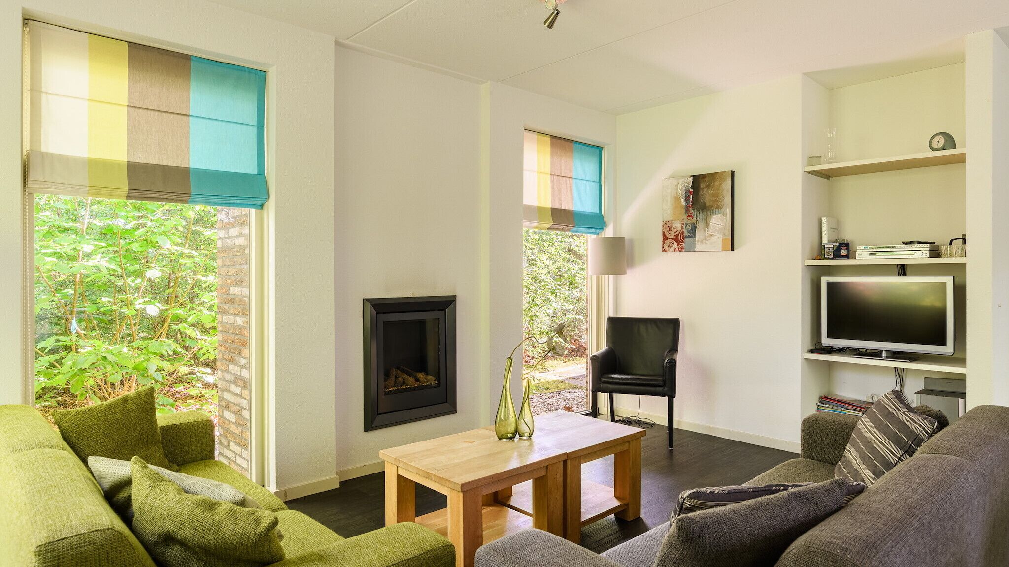 Una sala de estar con chimenea, televisor y estantería.