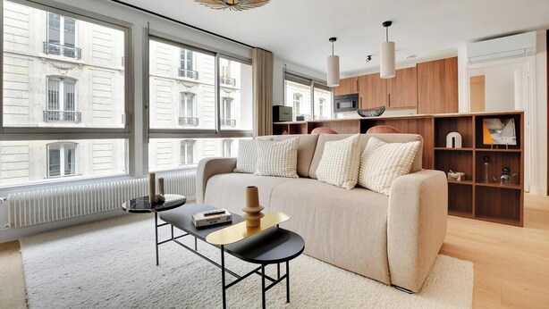 A modern living room with a sofa, a coffee table, and a bookshelf. - SERENE AMBIANCE,JUST MOMENTS FROM TROCADÉRO – CHAMPS ELYSEES AT RUE DE L'AMIRAL (Paris)