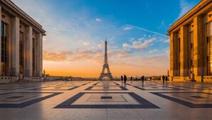 The Eiffel Tower with a clear sky and a plaza with large columns and statues. - SERENE AMBIANCE,JUST MOMENTS FROM TROCADÉRO – CHAMPS ELYSEES AT RUE DE L'AMIRAL (Paris)
