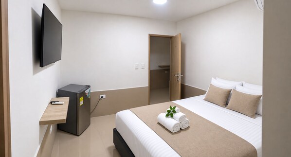 A hotel room with a bed, a desk, a television, and a wardrobe. - Hostal Tamaca (Santa Marta)