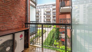 A balcony with a view of a brick building and a garden. - Lion Apartments - Apartment in Old Town (Gdansk)