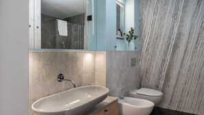 A modern bathroom with a freestanding sink, a toilet, and a bidet. - Lion Apartments - Apartment in Old Town (Gdansk)