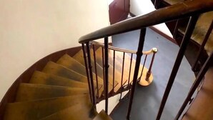 A spiral staircase with wooden steps and metal railings. - L'appartement Boulnois (Paris)