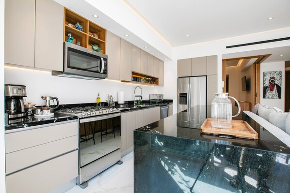 Una cocina moderna con una isla central, electrodomésticos integrados y un diseño minimalista.