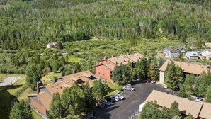 A residential area with multiple houses, a parking lot, and a mountainous backdrop.