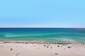 A beach with umbrellas and people. - 🌅 Beachfront Views | SunDestin 1403 (Destin)