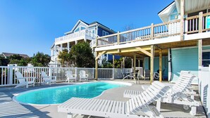 A pool area with lounge chairs and a wooden deck. - Spectacular views from this 2nd Row East side Duplex - New for 2025 Shared Pool (Emerald Isle)