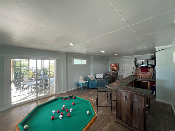 A pool table with balls, a bar area, and a seating area with a view to the outside. - Spectacular views from this 2nd Row West side Duplex - New for 2025 Shared Pool (Emerald Isle)