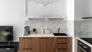 Een moderne keuken met een marmeren achterwand, houten kastjes en een ingebouwde oven.