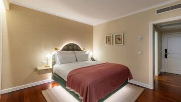Une chambre à coucher avec un lit, des lampes de chevet, un tapis et une porte.