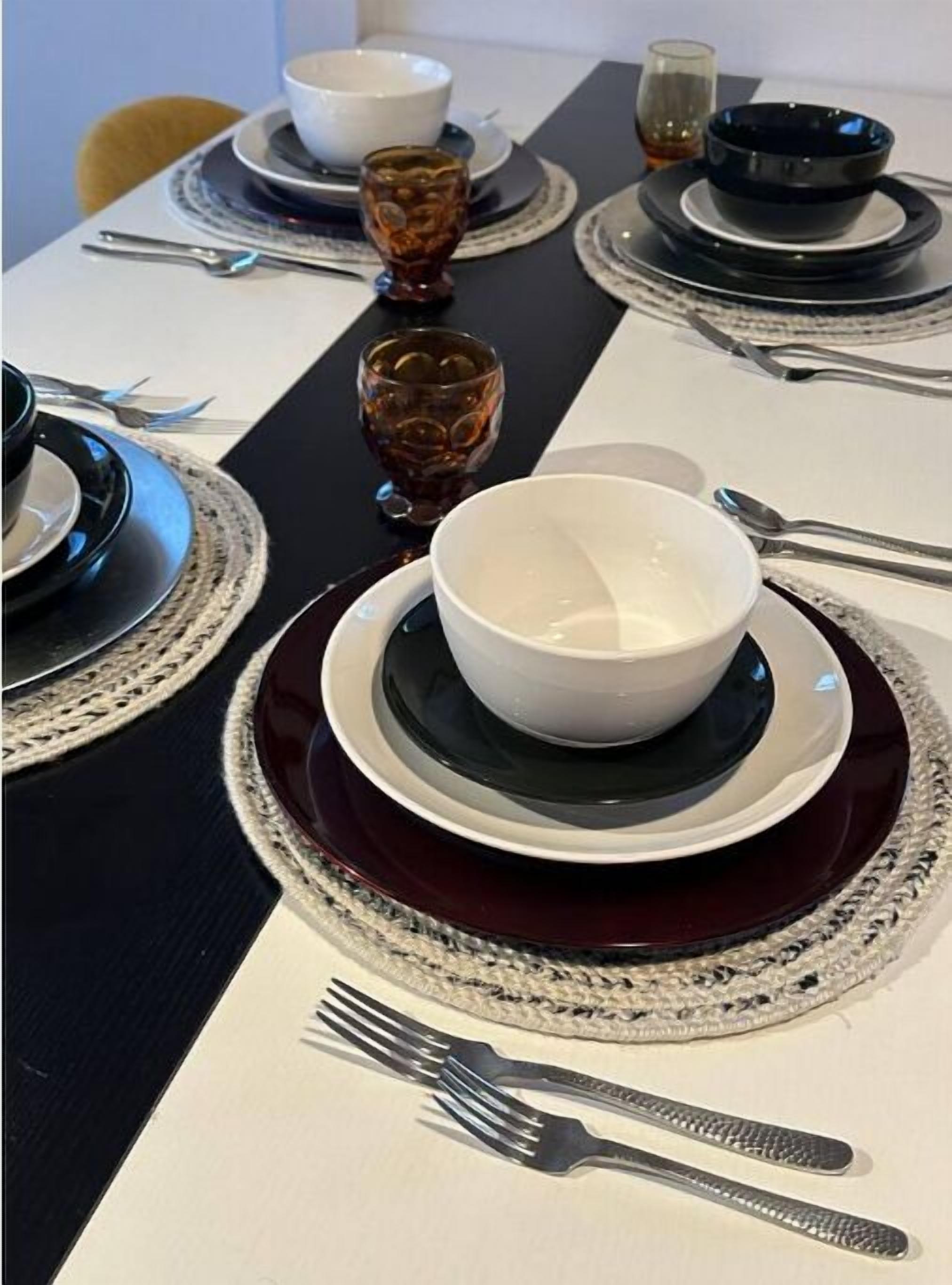 A neatly set dining table with multiple plates, bowls, and glasses.