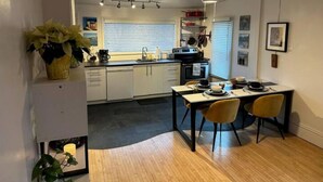 Cocina compacta con comedor, que incluye una estufa moderna, un lavamanos y un ventilador de techo.