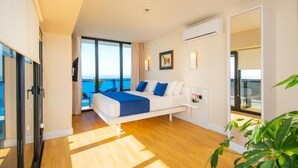 A modern bedroom with a bed, a bedside table, a window with a view, and an air conditioning unit. - ORBI CITY Apart-Hotel Georgia Batumi (Batumi)