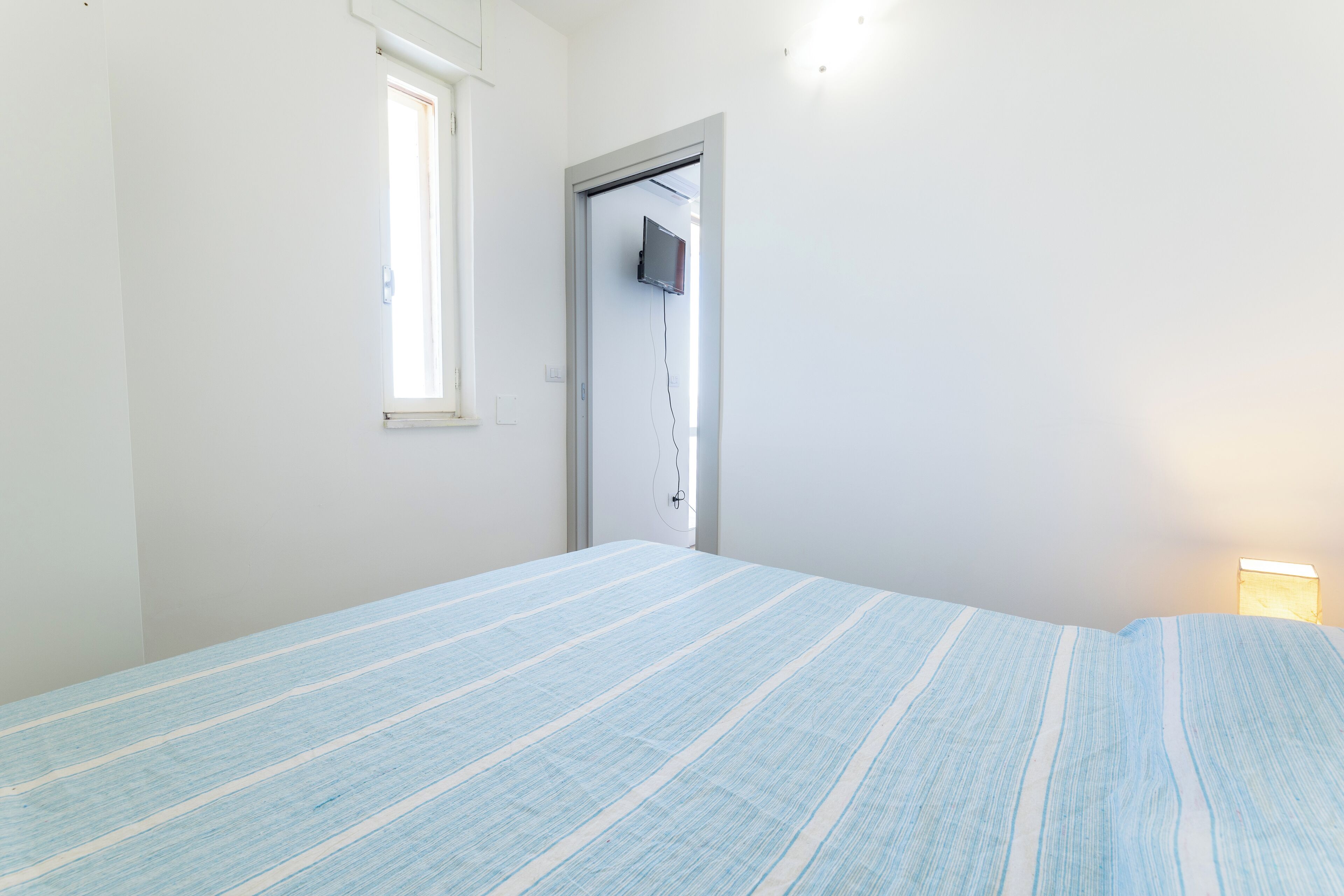 Ein Schlafzimmer mit Bett, Fenster und Tür.
