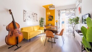 A modern living space with a dining area, a yellow sofa, a cros - HOUSE OF MUSIC in Pigneto, METRO C to Colosseo (Roma)