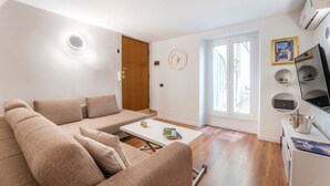 A modern living room with a sofa, coffee table, and a television. - Villafranca Loft , Modern Studio Nearby the Station (Roma)