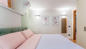 A bedroom with a bed, a green headboard, and two wall-mounted light fixtures. - Villafranca Loft , Modern Studio Nearby the Station (Roma)